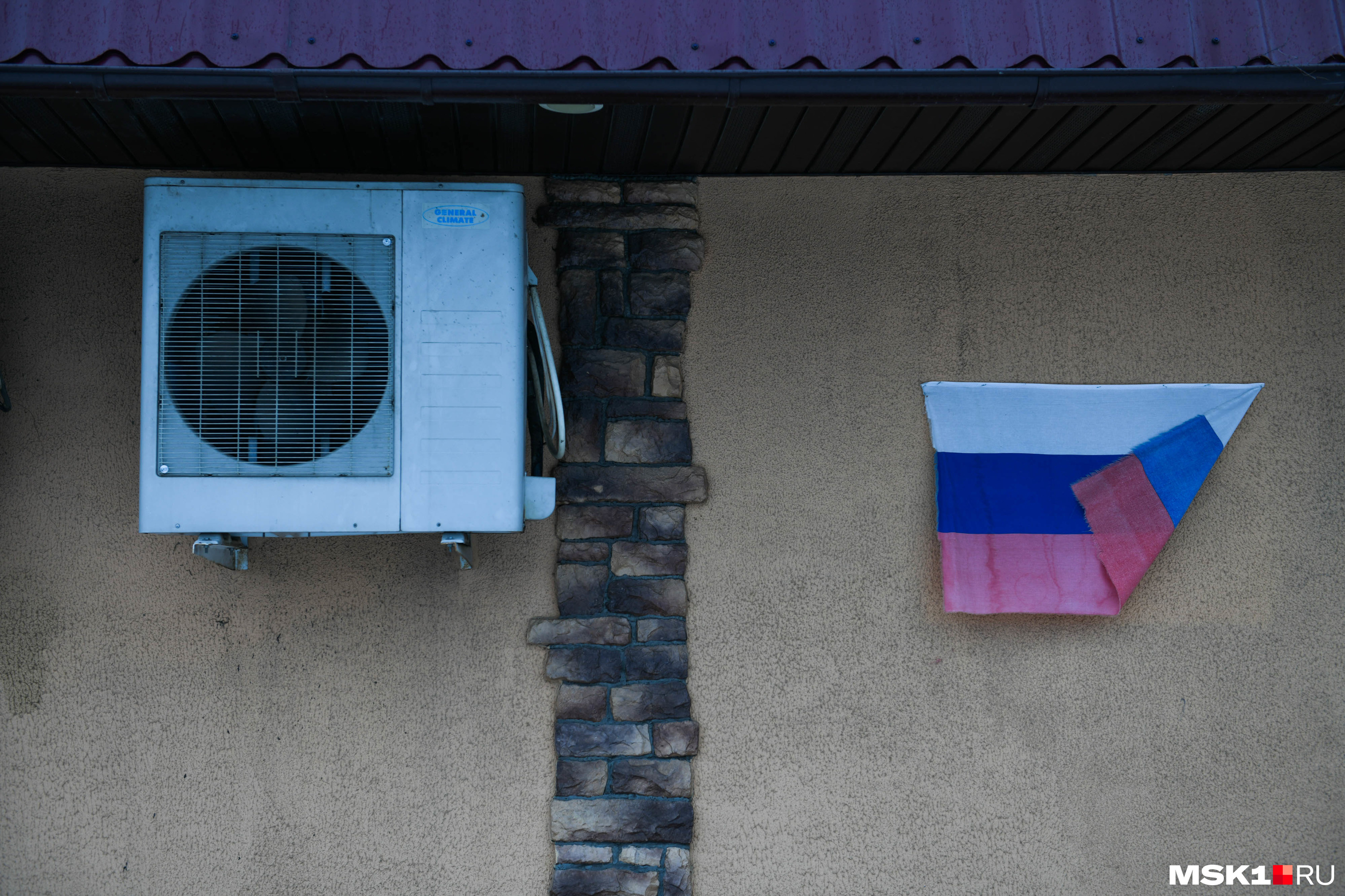 На стенах продуктового магазина развевается немного выцветший российский флаг